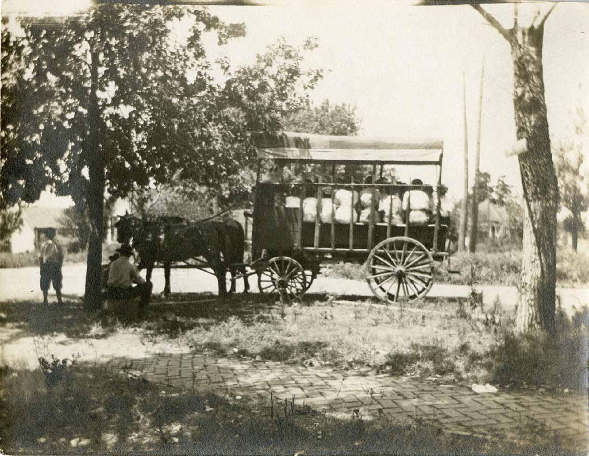 Antique photo of people packed in a traveling carriage